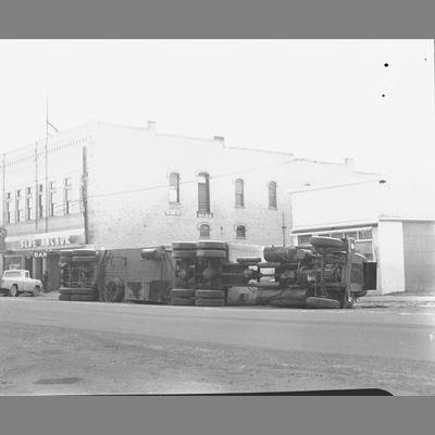 A Turned over Semi Truck in Front of Shops in Twin Bridges, Montana 1962