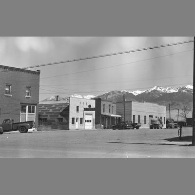 Street with business buildings and parked cars.