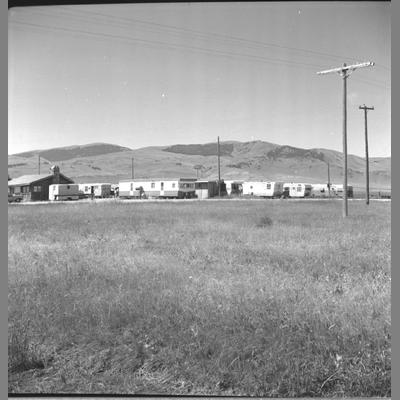 Group of mobile homes in middle distance in Armstead, Montana, July 1962.