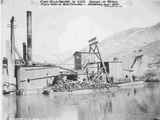 Side View of Steam Operated Dredging Machine with Piles of Firewood Stacked on Deck Near Water Line ca. 1890