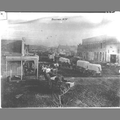 Line of Covered Freight Wagons Stretching Down Bozeman Main Street, 1875