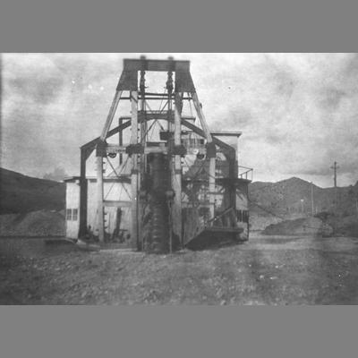 Piles of Debris and Hillsides Visible Behind the Alder Steam Dredge in Alder, Montana