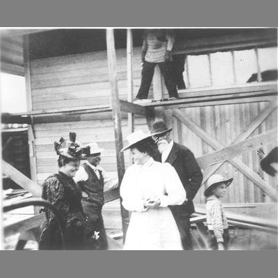M. H. Lott Standing with Others in Front of Scaffold Against a Wooden Storefront circa 1900