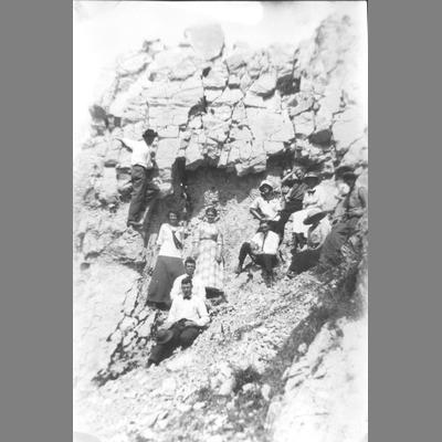 Group of Men and Women Posing for an Informal Snapshot Against Large Rock Formation circa 1920
