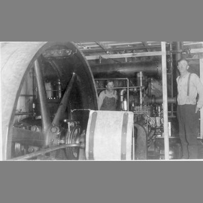 Two Mechanics Pose While Working with Elaborate Machine