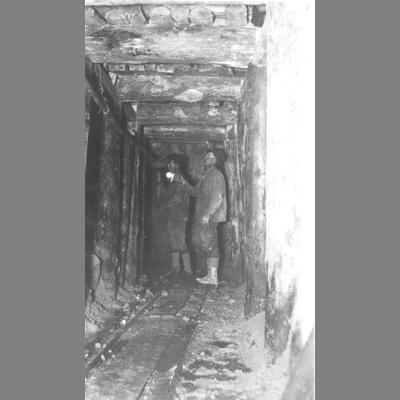 Two Miners in Underground Tunnel, Shored Up with Heavy Timbers