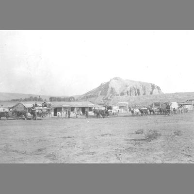 Long Distance View of Three horse-drawn Wagons Drawn in Front of Rock Stage Station 1895