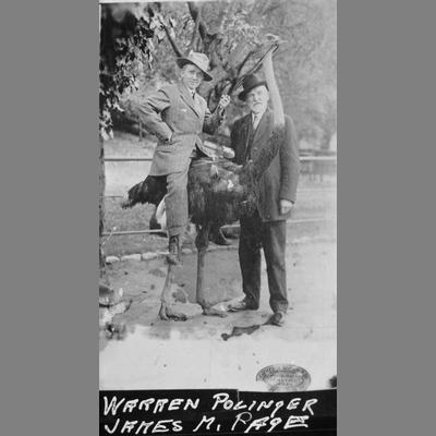 James M. Page Stands Next to Warren Pollinger Seated on Ostrich With Fitted Bridle