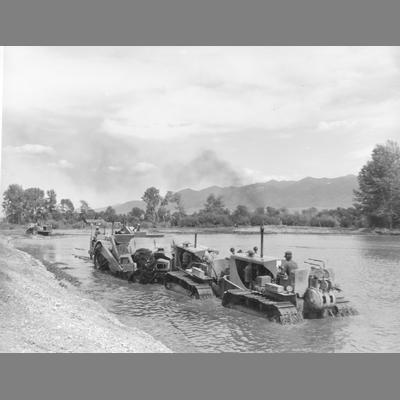 View of Bulldozers and Grading Machines Moving Through Riverbed