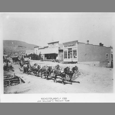 Freight Team of Eight Horses Passing By Wood Frame Storefronts ca. 1900s