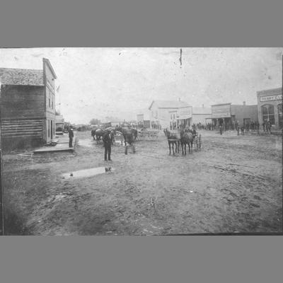 View of muddy Main Street with wood framed false front businesses, Sheridan, Montana, 1890.