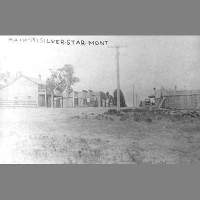 Mid Distance Ground Level View of Wood Frame Business Buildings on a Dirt Main Street, Silverstar, Montana