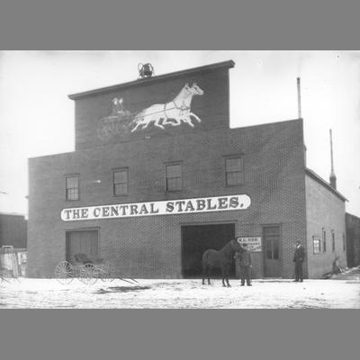 Two Men Stand With Horse and Unhitched Buggy in Front of Central Stable 1890s