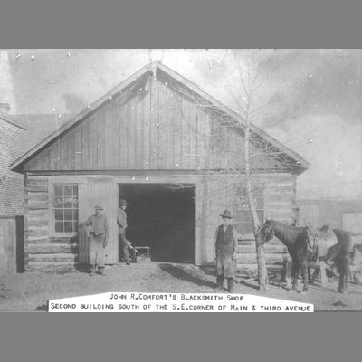 Three Men and Horse Stand in Front of John R. Comfort's Blacksmith Shop