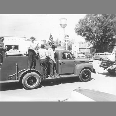 Men Ride on Small Truck Outfitted for Firefighting During Twin Bridges Parade circa 1950