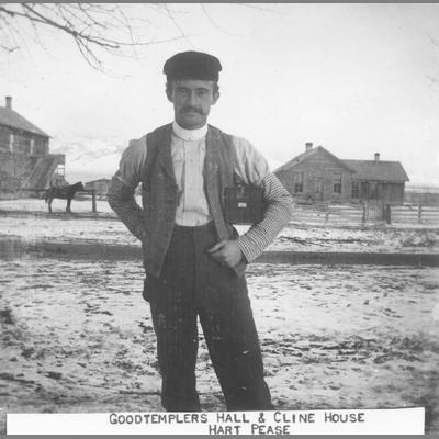 Hart Pease Stands in Front of Good Templars Hall and Cline House