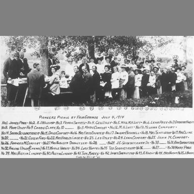 Group of Pioneers Seated at a Long Picnic Table 1914
