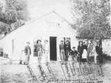 Group of Men and Women Standing in Front of Stark Hotel located in Twin Bridges, Montana 1893