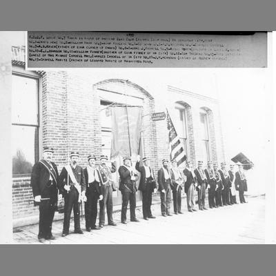 Virginia City Odd Fellows in Lodge Uniforms Standing on Sidewalk in Front of Brick Commercial Building