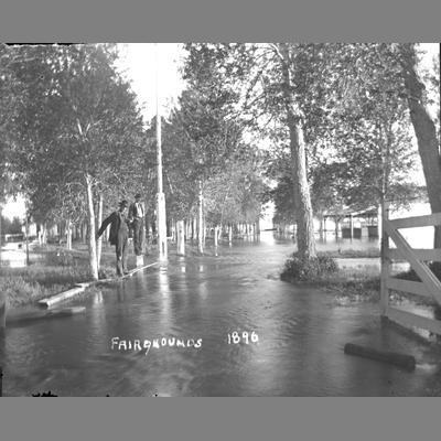 Two men observe the flood near the fairgrounds in Twin Bridges, Montana, 1896.