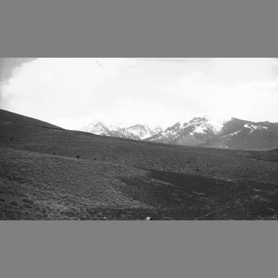 Open Field With Snow Capped Mountains in Background