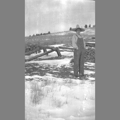 Black and White Photograph of Farmer Standing in Snowy Field