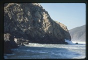 Monterey, California - waves crash against a large rock formation on the coastline