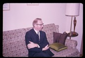 Ivan Doig sits with arms crossed on a couch