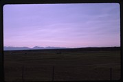 Dupuyer Creek and Rockies during haying season at sunset