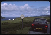 Isle of Skye, Scotland - a car parked next to a passing notice near the ocean