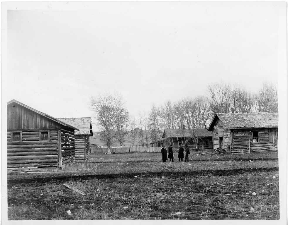 Four unidentified men inspecting ruins of Fort Logan (Camp Baker)