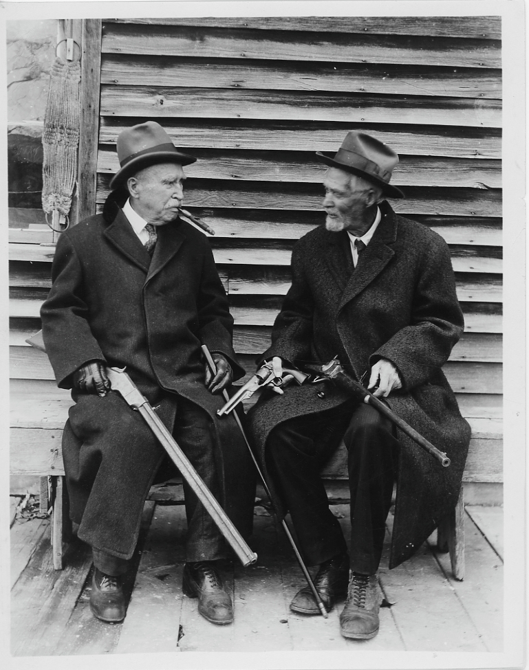 Two men sitting at the Fort Logan (Camp Baker) ruins