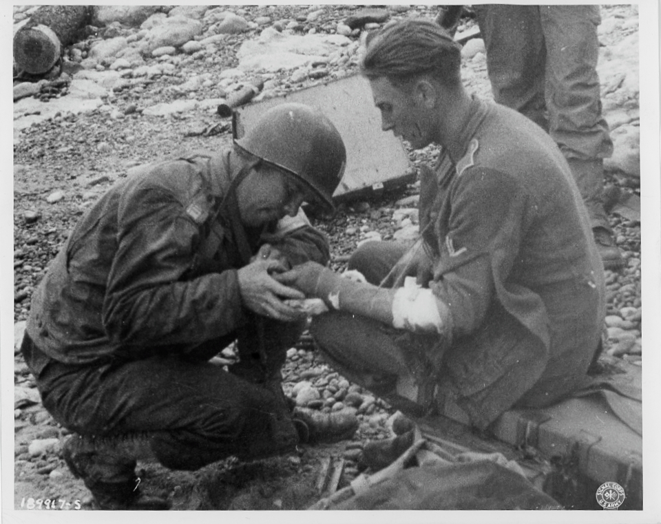American medical officer treating a wounded German prisoner