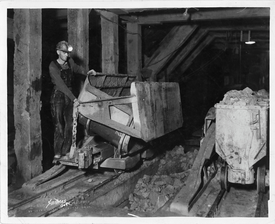 Butte miners working with mine carts loaded with rock