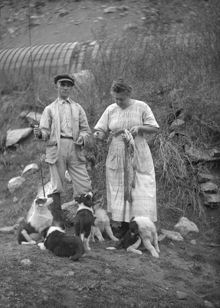 Two People at the Madison Power Plant with Large Fish and Dogs, Beartrap Canyon, Montana