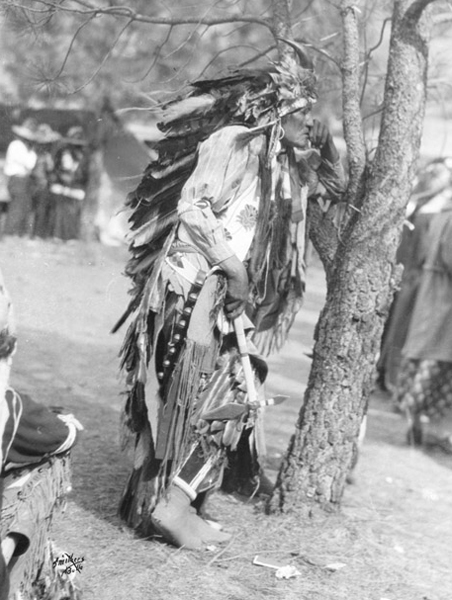 A Flathead Indian Man Leaning on a Tree, with Headdress, Unknown Location