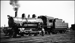NP 27, a 2-8-0 at Billings, MT with crewman on ground looking at air pump running gear.