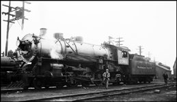 NP 2263, a 4-6-2 Pacific Class Q-6, at Seattle, Washington.  An unidentified photographer walks away as the conductor looks on.