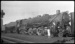 NP 2654, Class A-2 on way to shops after being wrecked pulling train No. 1, when it hit washout near Hebron, ND, Eccentric straps and pilot removed.  Probably Mrs. Nixon posing in front of locomotive.