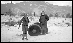 Unidentified people stand beside wheel assembly that is said to have a broken journal that caused wreck of Train No. 603 at Turah, MT. 
