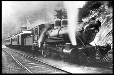 NP #253-93  Wallace  about 1913  cy Beebe NP class F-4  2-8-0 on two car psgr train at Wallace depot.The top floor of the depot, now moved across the river and serving as a museum, is visible behind the rear of the train   Unidentified engine crew on ground by engine 93 [Grant,1887]  #93 was originally Montana Union 152  Became NP 136, renum 111 again to 93  