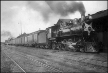 NP 281, Class Q, 4-6-2 at station with passenger train in Missoula. Crew servicing train.