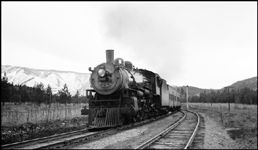 Passenger Extra 2193 East passes the west siding switch at Spring Gulch, Montana. Extra 5141 West is in the siding. The passenger extra is bringing troops home in the months after the end of World War II. Engine 2193 is a Class Q-4 4-6-2 built by Baldwin in October 1909. 