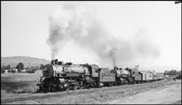 Doubleheaded Q-5 Pacifics, instead on the usual Northern, head the seond section of the North Coast Limited west.  This is the Pullman section, with a railway post office car right behind the engines.  While the engines have long left the tunnel to the rear, locomotive smoke is still pouring out.