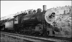 An engine extra west, two locomotives moving to a switching assignment after a visit to the shops (note the fresh paint) are paused in a siding.