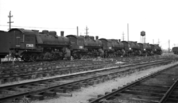 String of new USSR steam locomotives in Portland, OR, boarded up for possible shipping to USSR.  Locomotives only, no tenders connected.