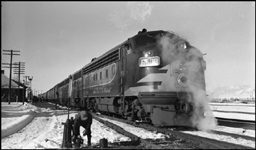 Switchman O'Neil thaws a frozen switch while NP 6509, an EMD F-7A, sits with the east bound Alaskan at Bozeman.