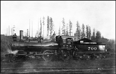 NP 700, Class C-3 locomotive with crew stopped in the woods at a logging operation for photo.  Former locomotive number NP 158.