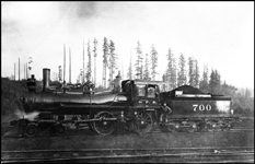 NP 700, Class C-3 locomotive with crew stopped in the woods at a logging operation for photo.  Former locomotive number NP 158.