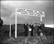 Descendents of Henry Villard, one of the early driving forces in the creation of the Northern Pacific pose below the sign commemorating the driving of the last spike on the NP.  One of the guests is an NP  stewardess nurse.